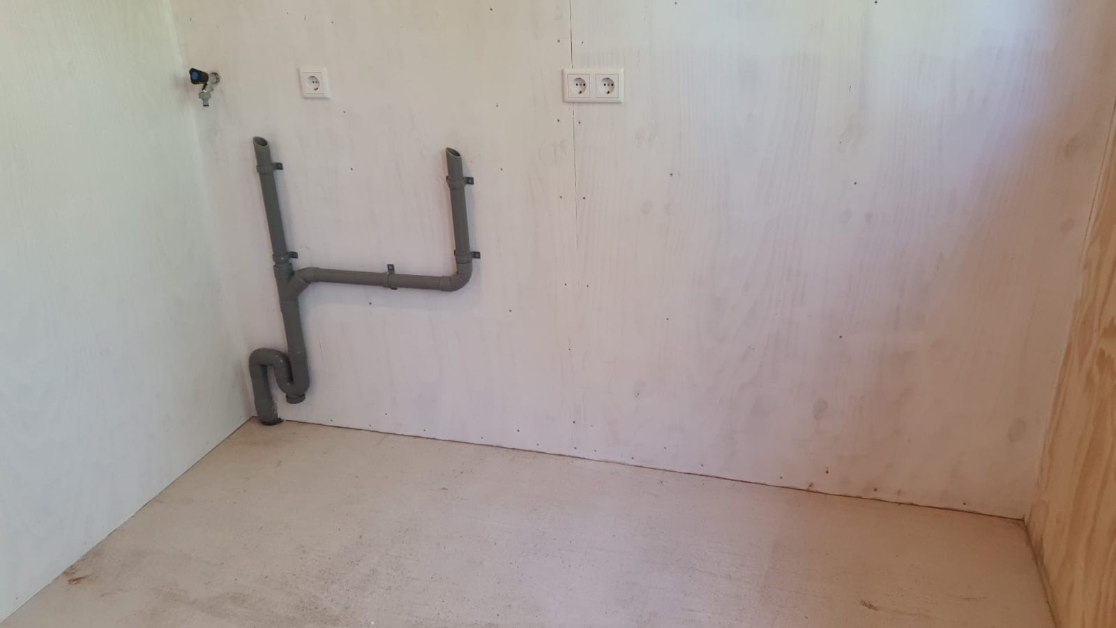 Utility room before, with the pipes and sockets in place